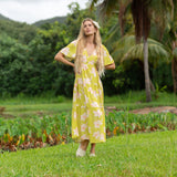 woman wearing a bright green v neck maxi dress with flutter sleeves with orchid print