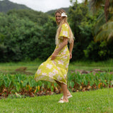 woman wearing a bright green v neck maxi dress with flutter sleeves with orchid print