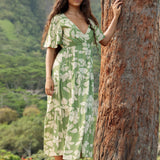 woman with brown hair wearing green v neck maxi dress with native Hawaiian plants 