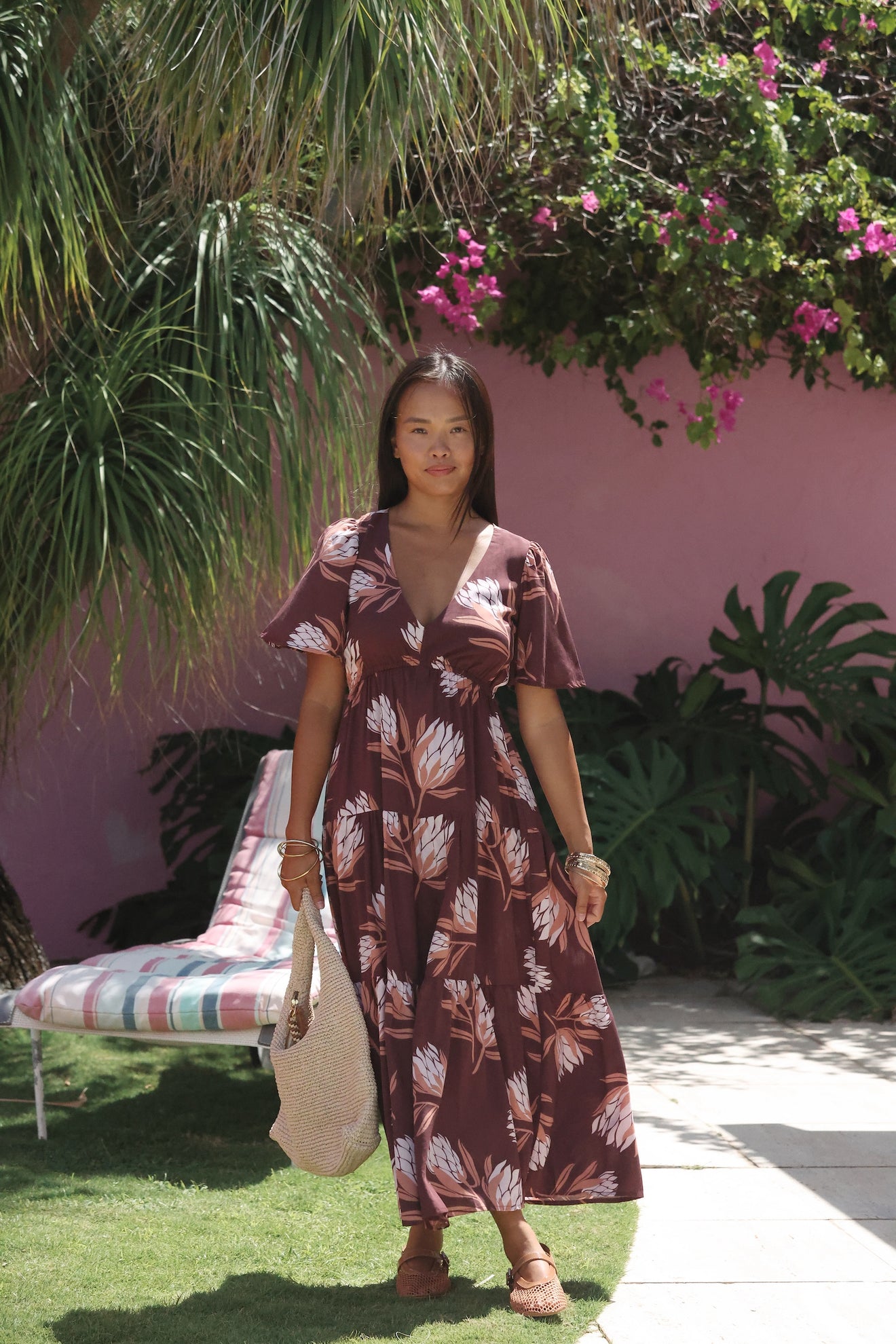 woman wearing brown maxi, v-neck, flutter sleeve dress with protea print