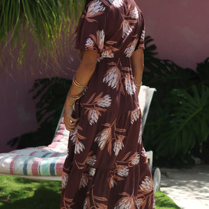woman wearing brown maxi, v-neck, flutter sleeve dress with protea print