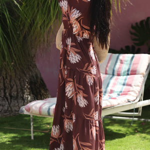 woman wearing brown maxi, v-neck, flutter sleeve dress with protea print