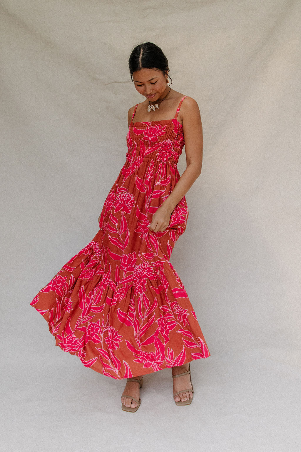 woman with brown hair wearing a spaghetti strap maxi dress with awapuhi print