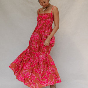 woman with brown hair wearing a spaghetti strap maxi dress with awapuhi print