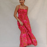 woman with brown hair wearing a spaghetti strap maxi dress with awapuhi print
