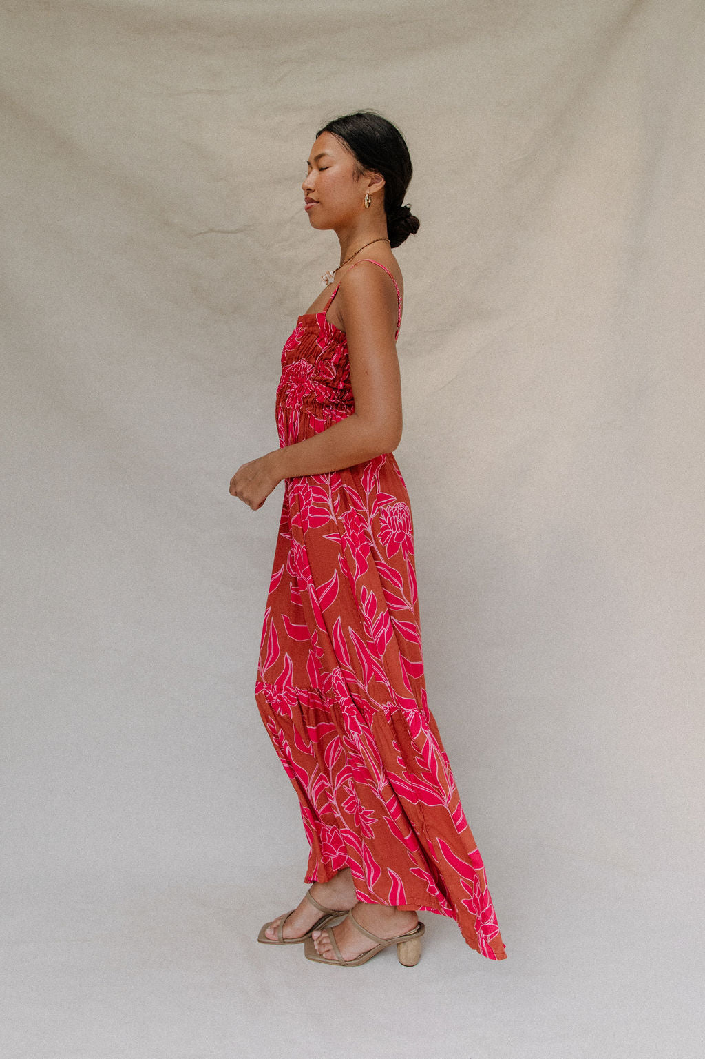 woman with brown hair wearing a spaghetti strap maxi dress with awapuhi print