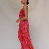 woman with brown hair wearing a spaghetti strap maxi dress with awapuhi print