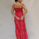 woman with brown hair wearing a spaghetti strap maxi dress with awapuhi print