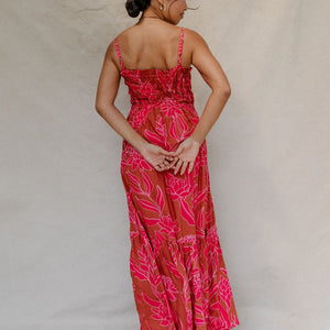 woman with brown hair wearing a spaghetti strap maxi dress with awapuhi print