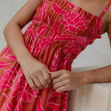 woman with brown hair wearing a spaghetti strap maxi dress with awapuhi print