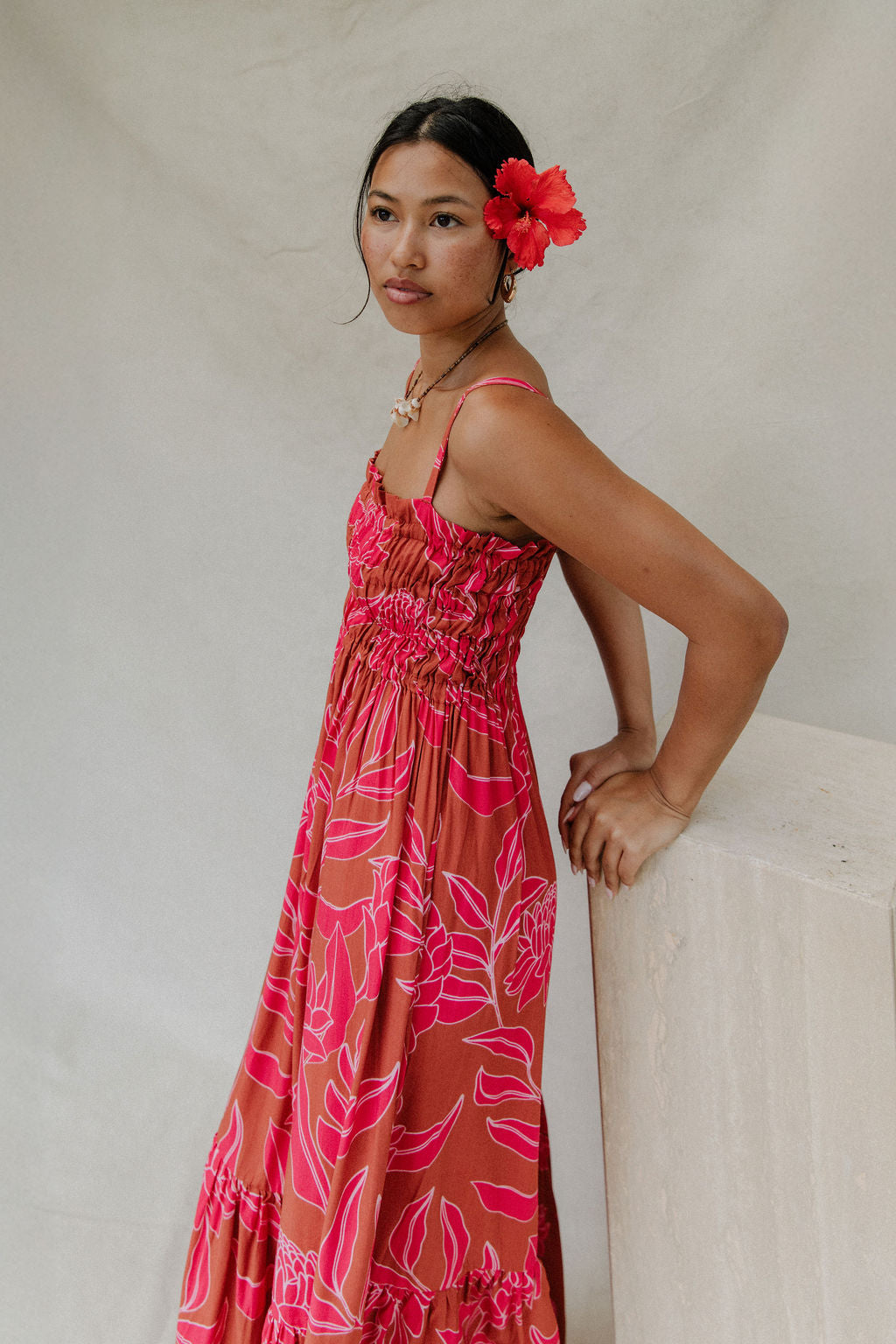 woman with brown hair wearing a spaghetti strap maxi dress with awapuhi print