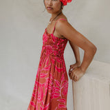woman with brown hair wearing a spaghetti strap maxi dress with awapuhi print
