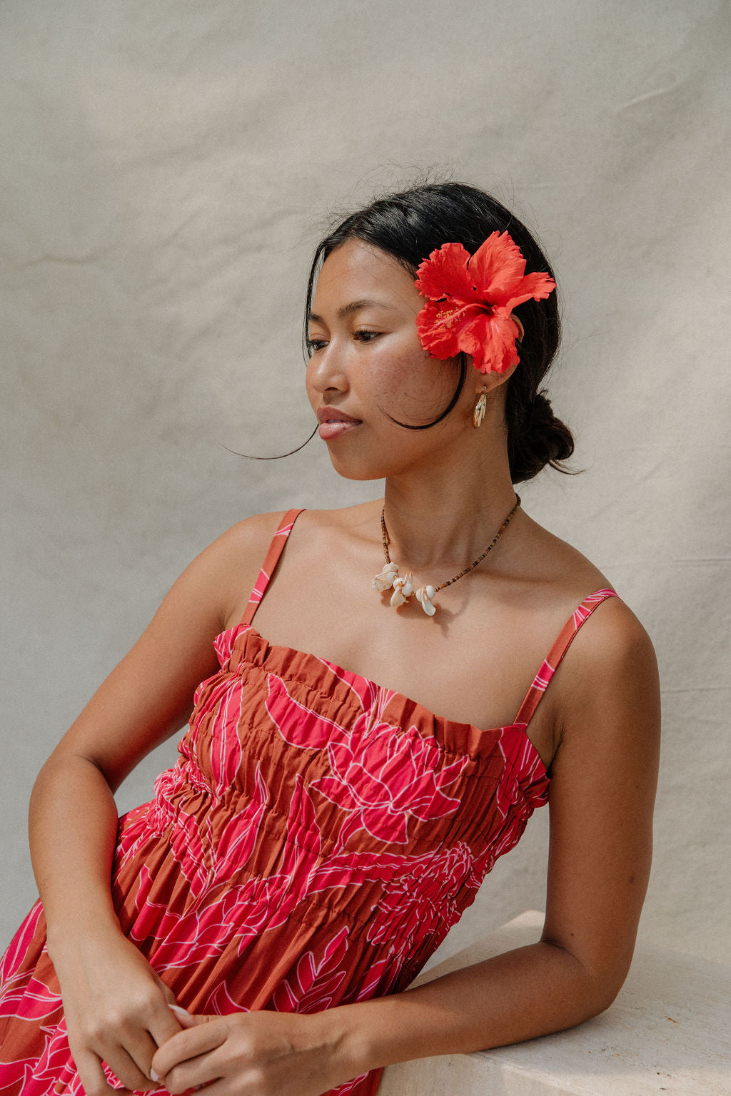 woman with brown hair wearing a spaghetti strap maxi dress with awapuhi print