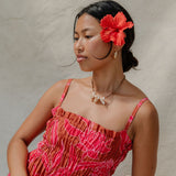 woman with brown hair wearing a spaghetti strap maxi dress with awapuhi print