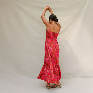 woman with brown hair wearing a spaghetti strap maxi dress with awapuhi print