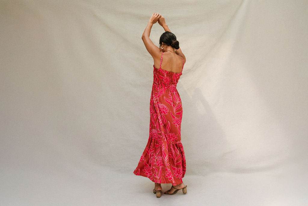woman with brown hair wearing a spaghetti strap maxi dress with awapuhi print