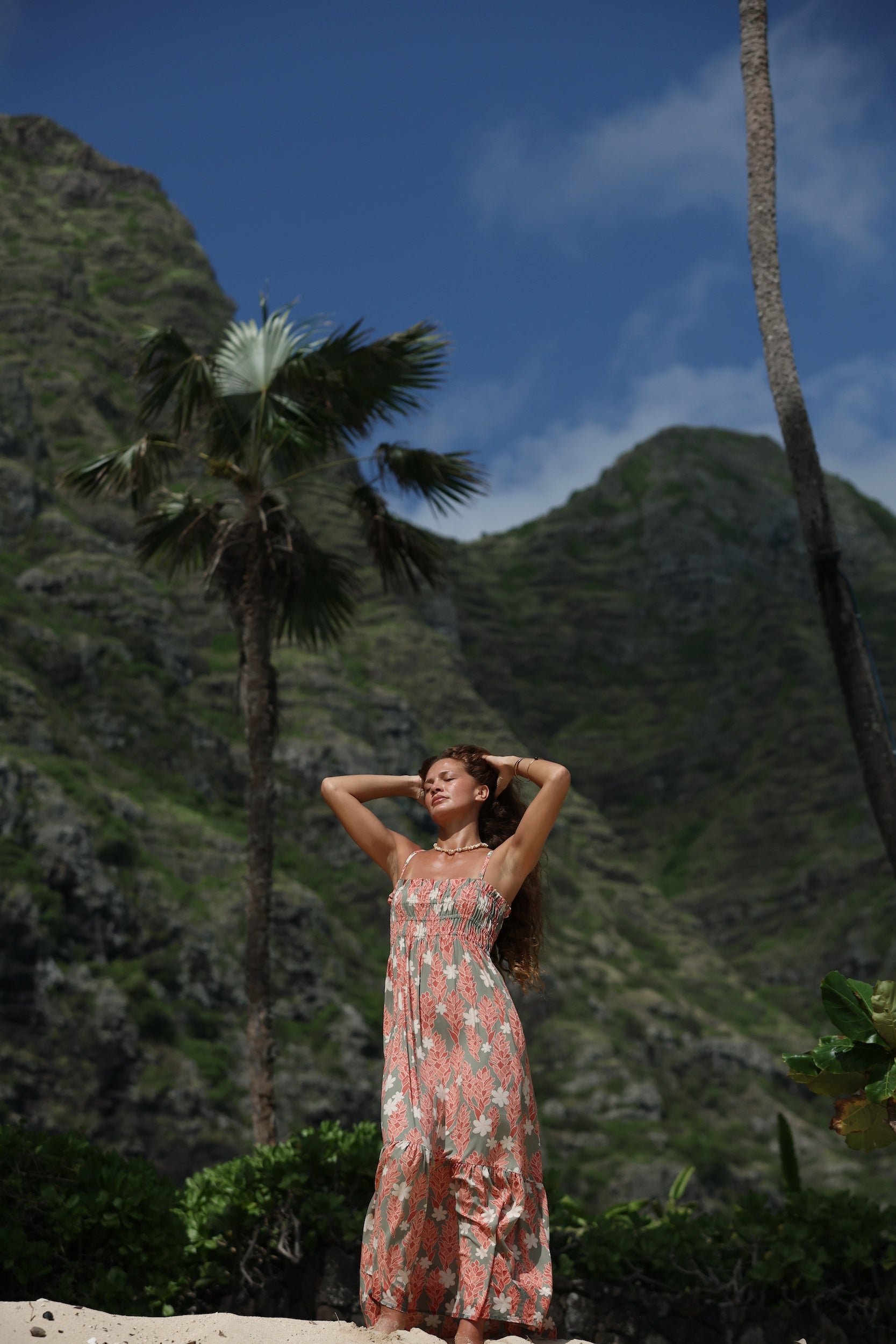 woman with blonde hair wearing jade colored maxi dress with tiare ginger print