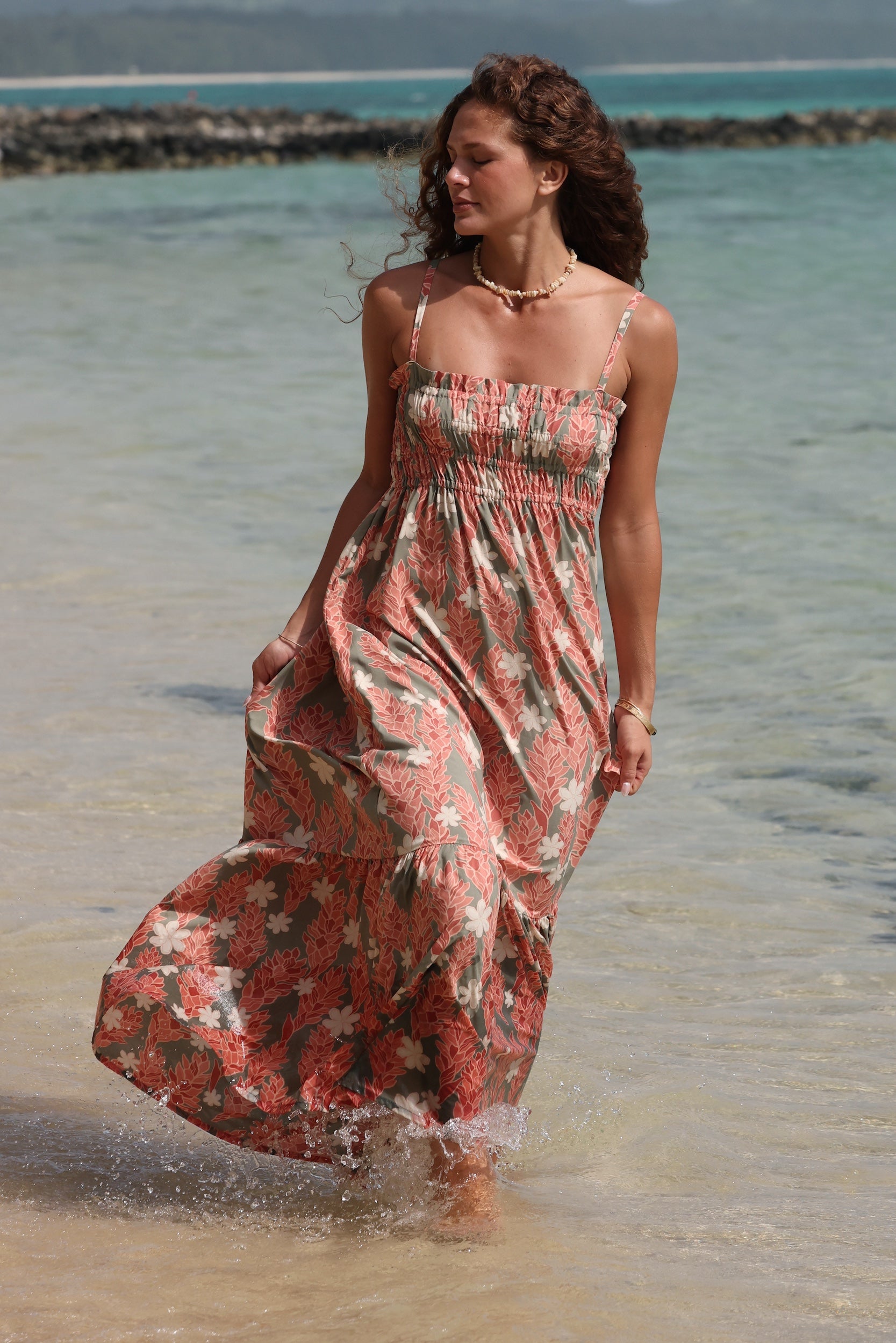 woman with blonde hair wearing jade colored maxi dress with tiare ginger print