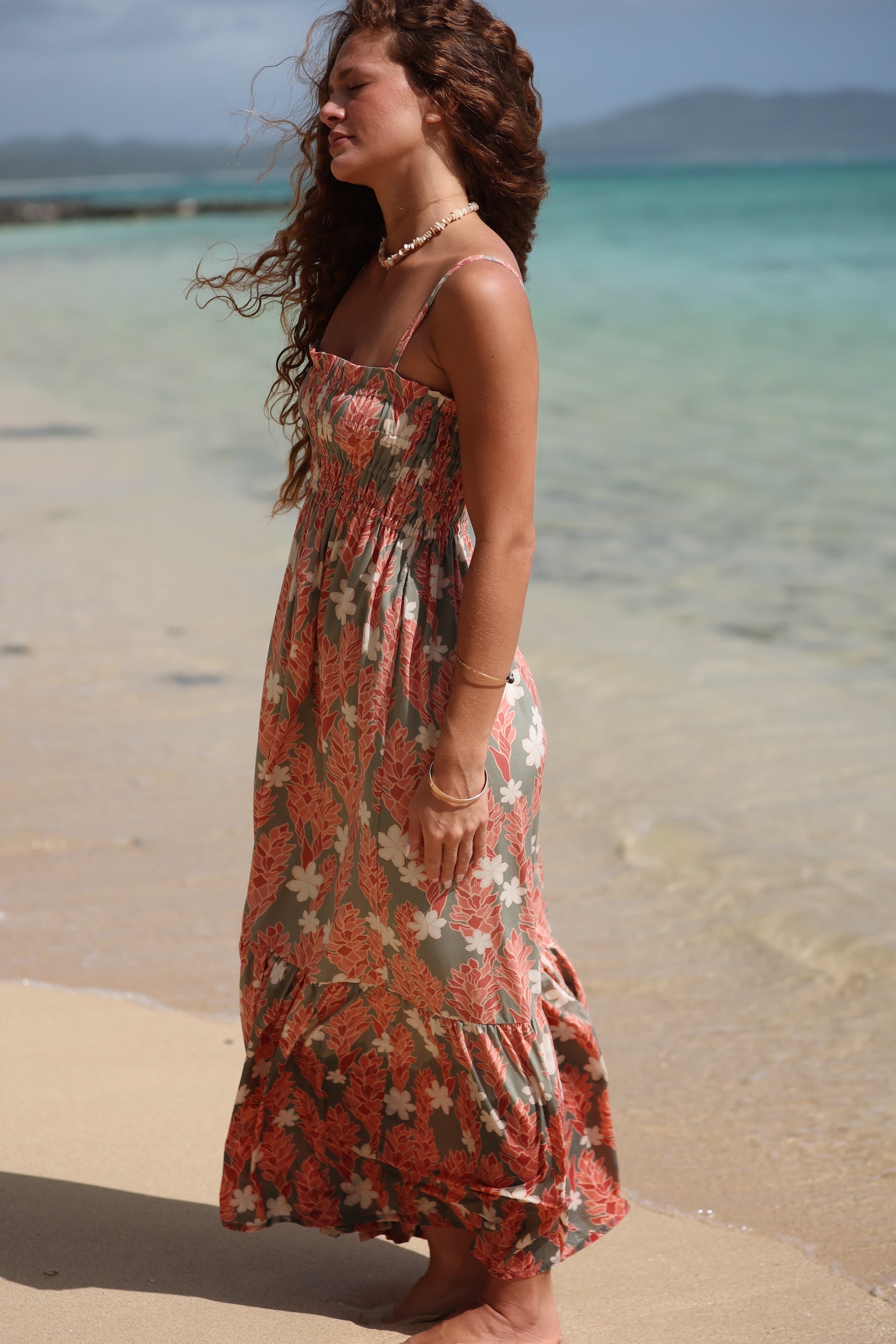 woman with blonde hair wearing jade colored maxi dress with tiare ginger print