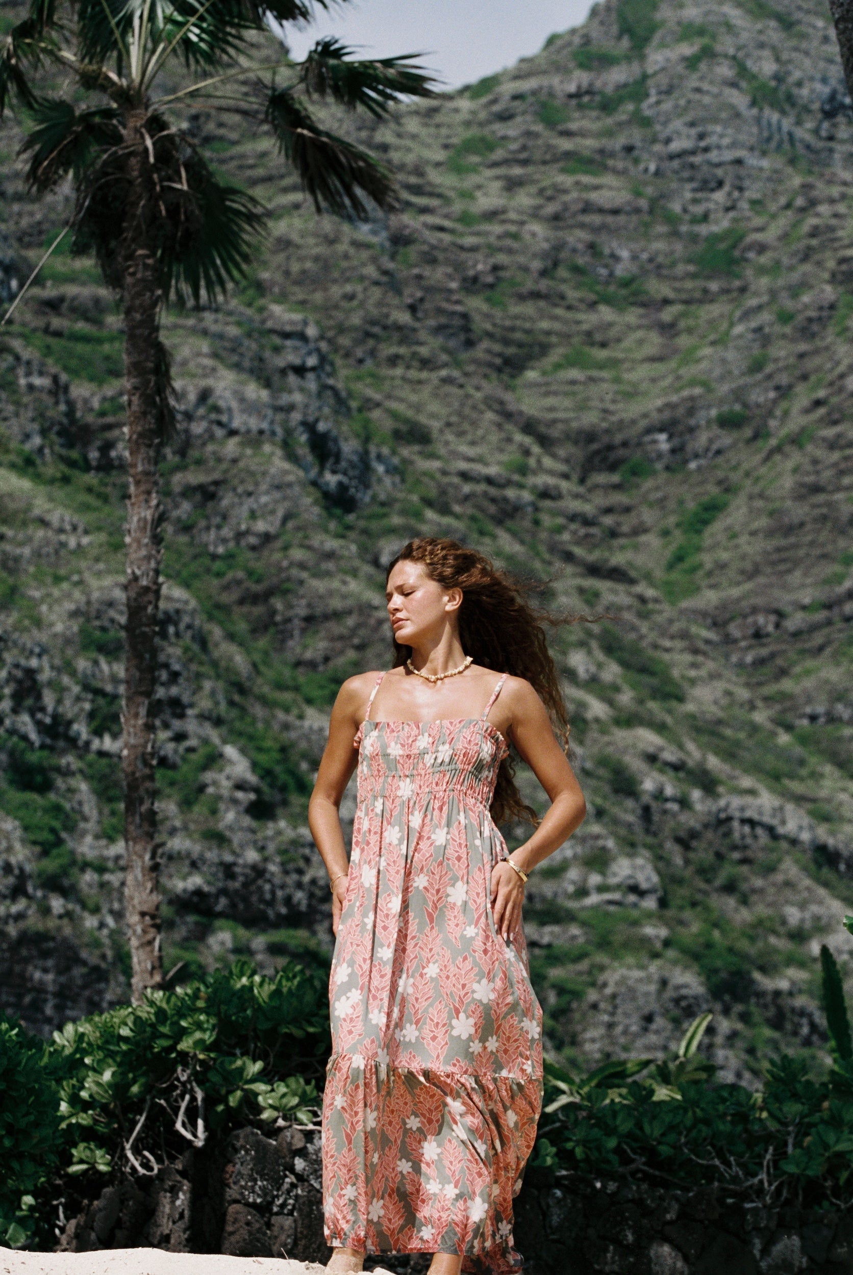 woman with blonde hair wearing jade colored maxi dress with tiare ginger print