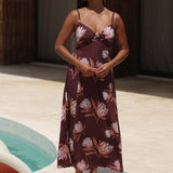 woman wearing a brown maxi dress with knot detail and protea print