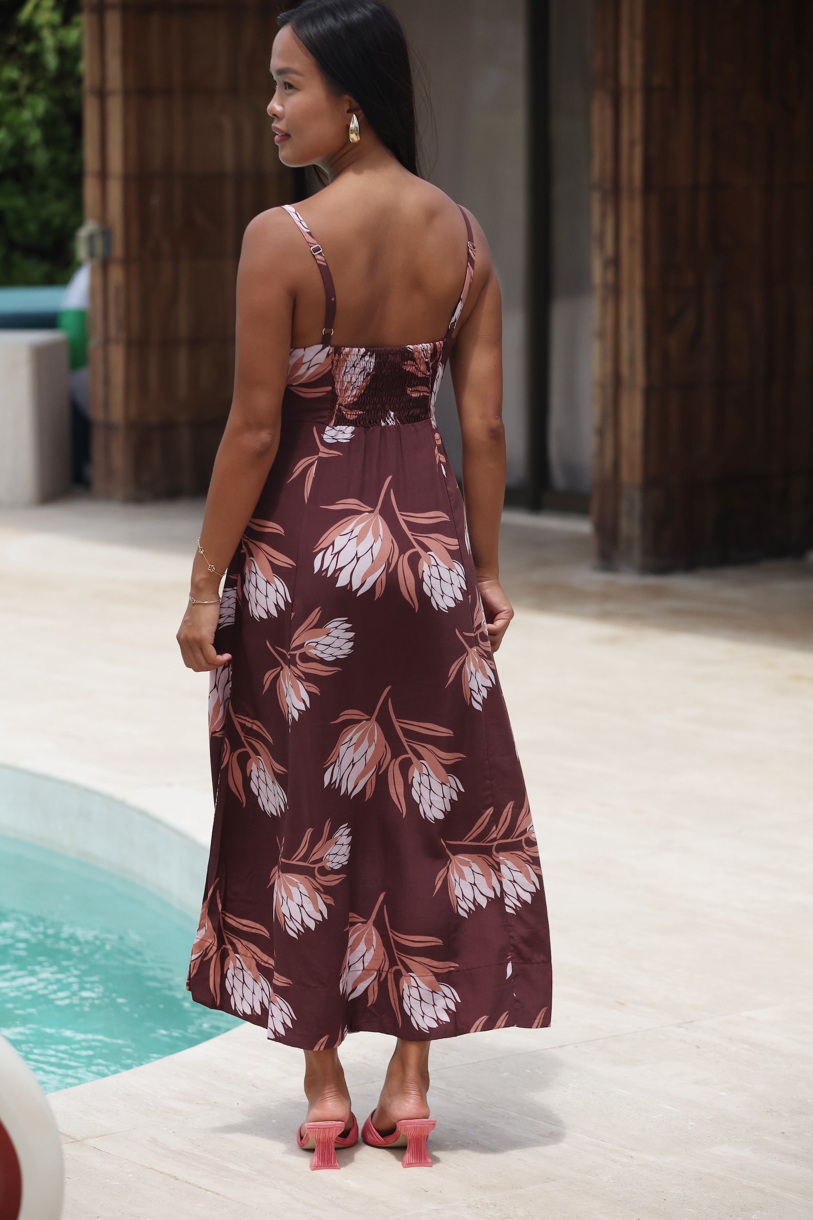 woman wearing a brown maxi dress with knot detail and protea print