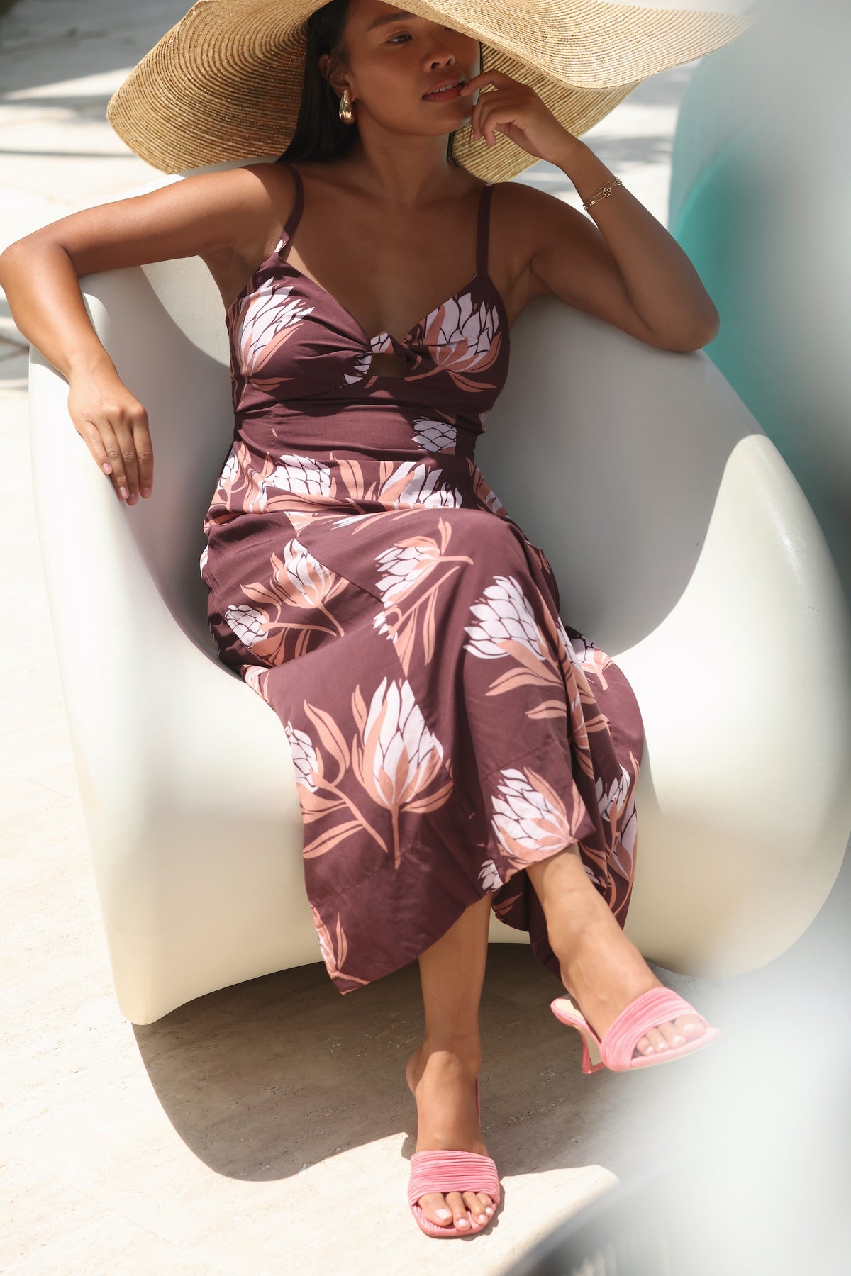 woman wearing a brown maxi dress with knot detail and protea print