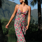 woman with brown hair wearing a teal maxi dress wth tie knot detail and shell and pua pattern