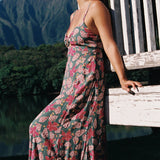 woman with brown hair wearing a teal maxi dress wth tie knot detail and shell and pua pattern