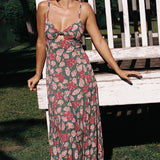 woman with brown hair wearing a teal maxi dress wth tie knot detail and shell and pua pattern