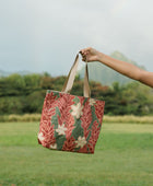 Woman with tote bag with red ginger flowers and beige tiare flower print.