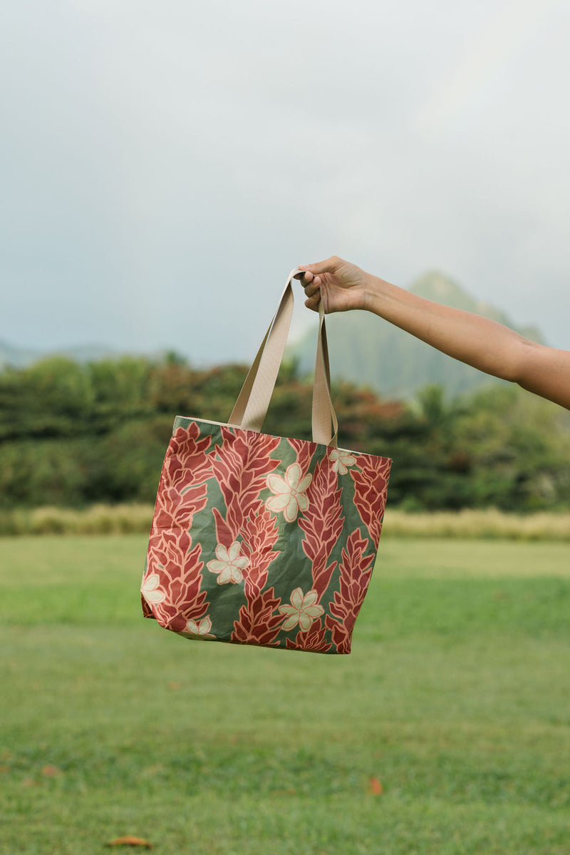 Woman with tote bag with red ginger flowers and beige tiare flower print.