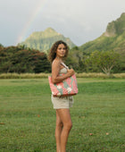 Woman with tote bag with red ginger flowers and beige tiare flower print.