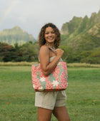 Woman with tote bag with red ginger flowers and beige tiare flower print.