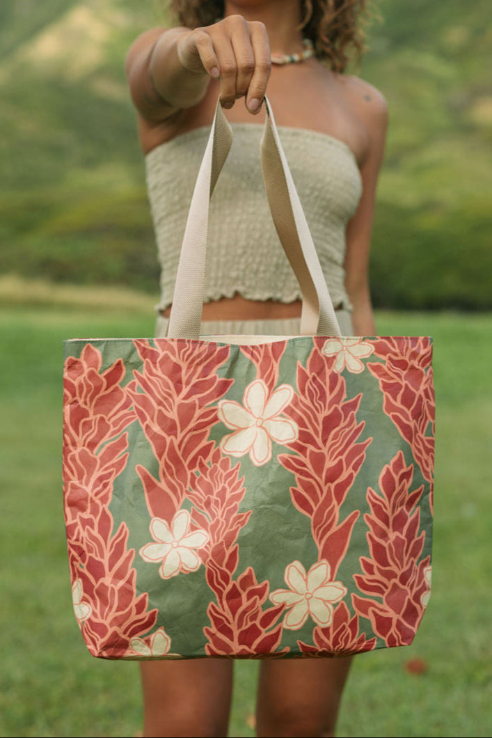 Woman with tote bag with red ginger flowers and beige tiare flower print.