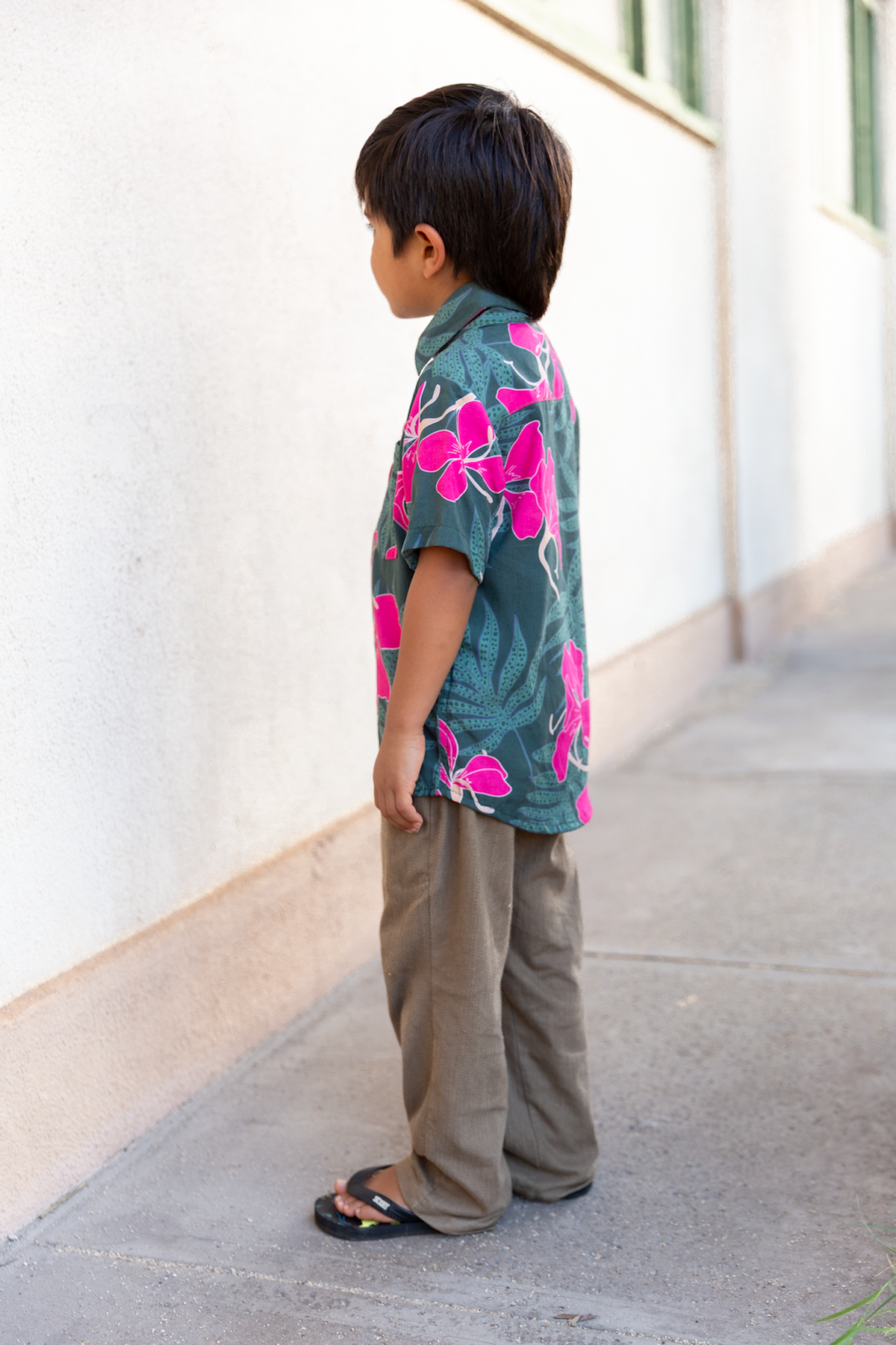 little boy with brown hair wearing mini aloha button up top with fern and ginger print