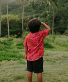 Boy in brown button up shirt with large pink floral print