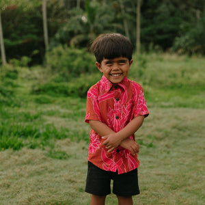 Boy in brown button up shirt with large pink floral print