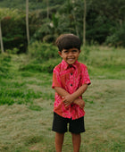 Boy in brown button up shirt with large pink floral print