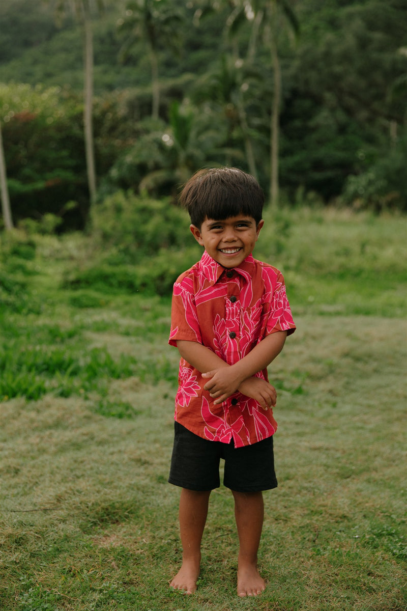 Boy in brown button up shirt with large pink floral print