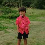 Boy in brown button up shirt with large pink floral print 