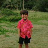 Boy in brown button up shirt with large pink floral print