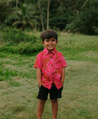 Boy in brown button up shirt with large pink floral print