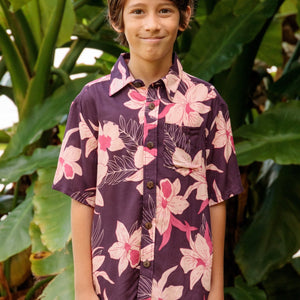 little boy wearing a dark purple aloha button up shirt with orchid print