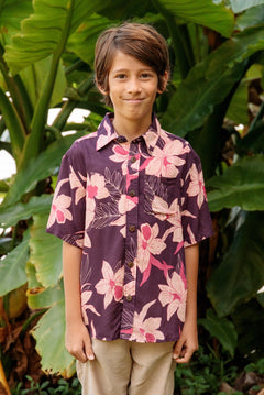little boy wearing a dark purple aloha button up shirt with orchid print