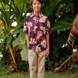 little boy wearing a dark purple aloha button up shirt with orchid print