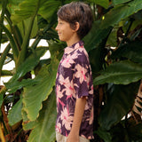 little boy wearing a dark purple aloha button up shirt with orchid print
