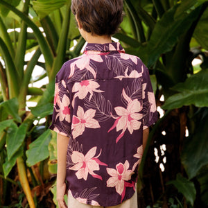 little boy wearing a dark purple aloha button up shirt with orchid print