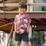 little boy wearing brown aloha shirt with pink lei awapuhi print