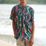 little boy wearing aloha button up shirt in dark teal with shell and lei print